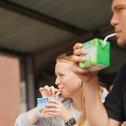 junge Frau und junger Mann trinken jeweils einen Eistee