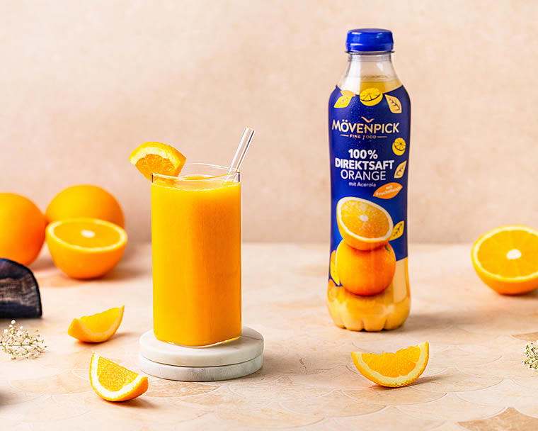 Glas mit Mövenpick Orangensaft dazu mOrangen geschnitten