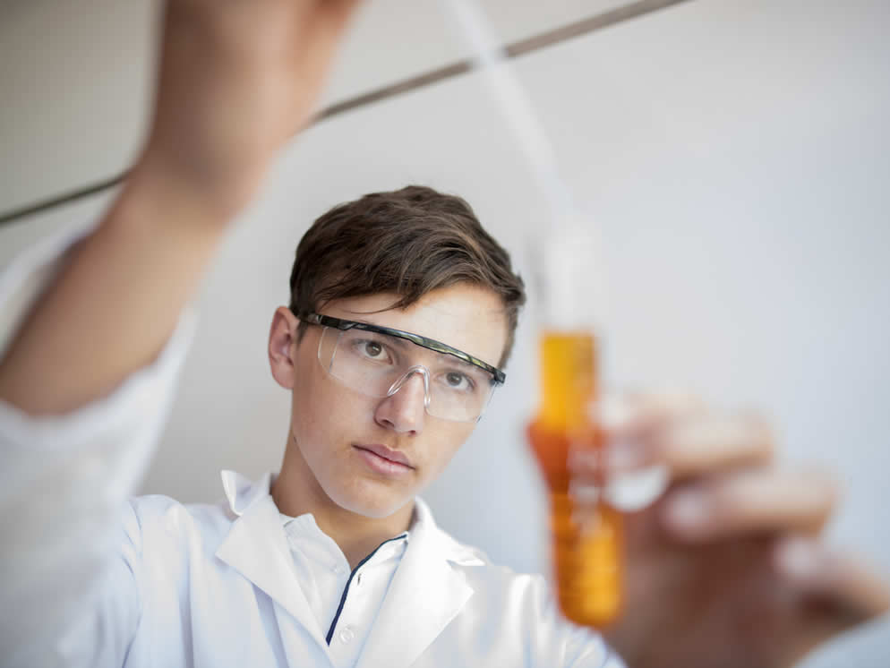 Mann prüft Saft im Reagenzglas nach Qualität